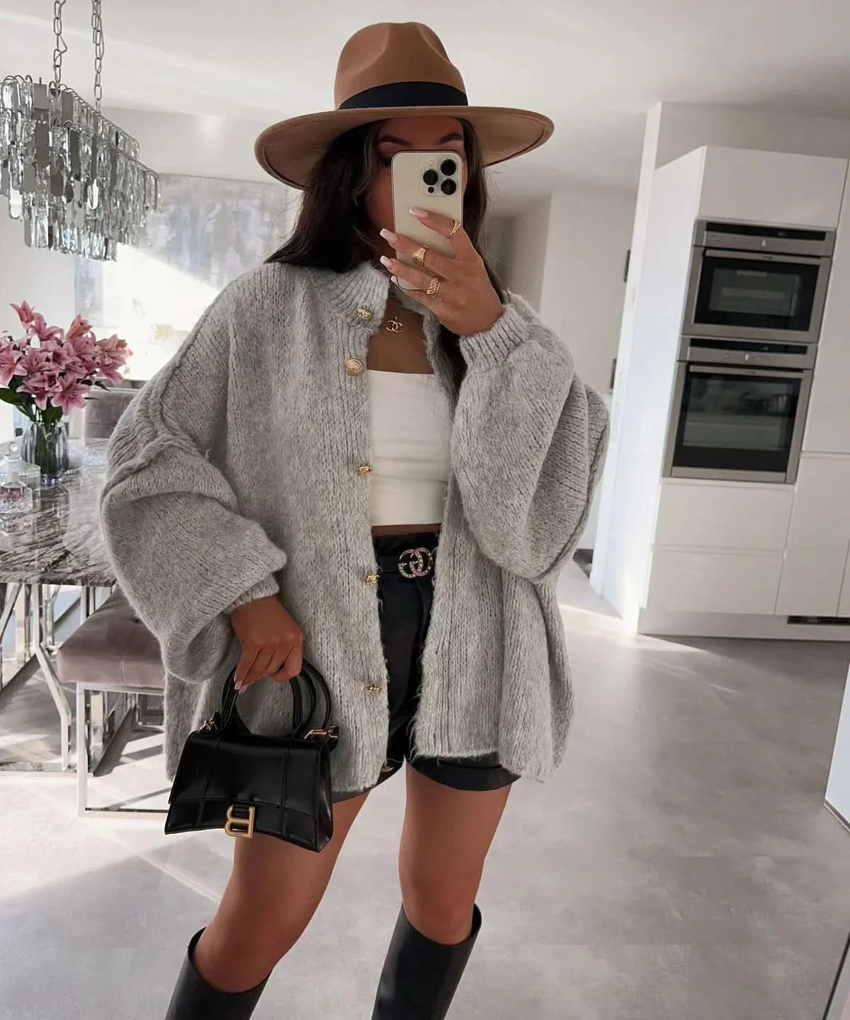 Gray oversized cardigan styled with white crop top and black shorts