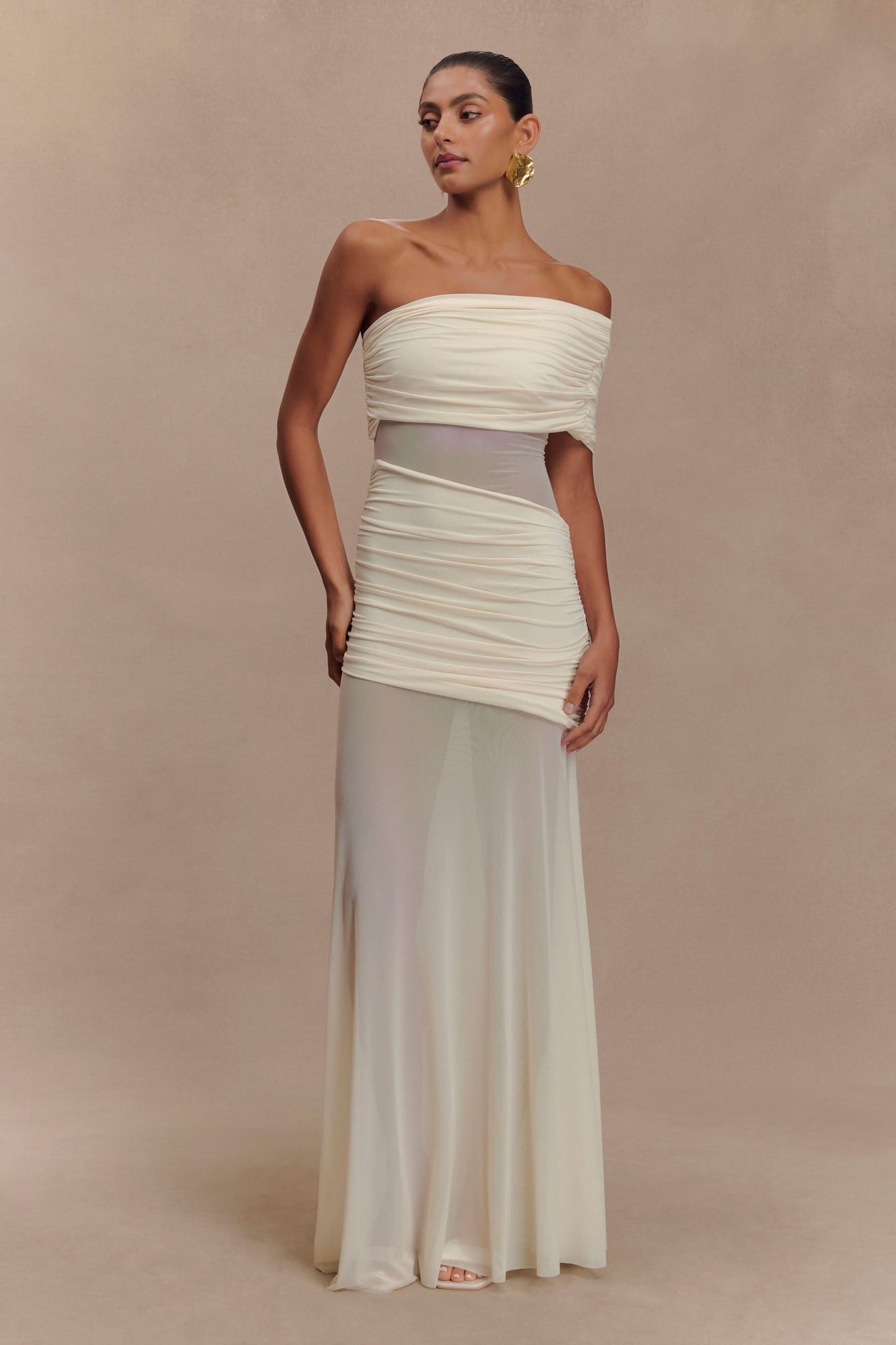 Cream off-shoulder evening gown with ruched bodice and flowing maxi skirt