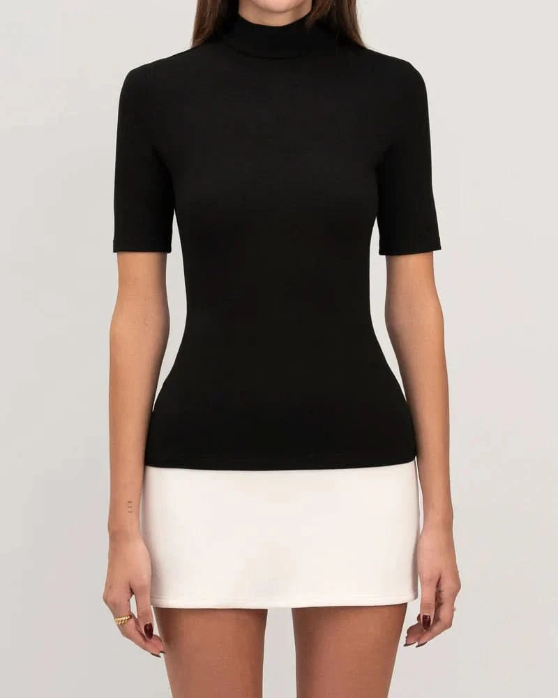 Close-up of black mock-neck bodycon top with white mini skirt color-block detail