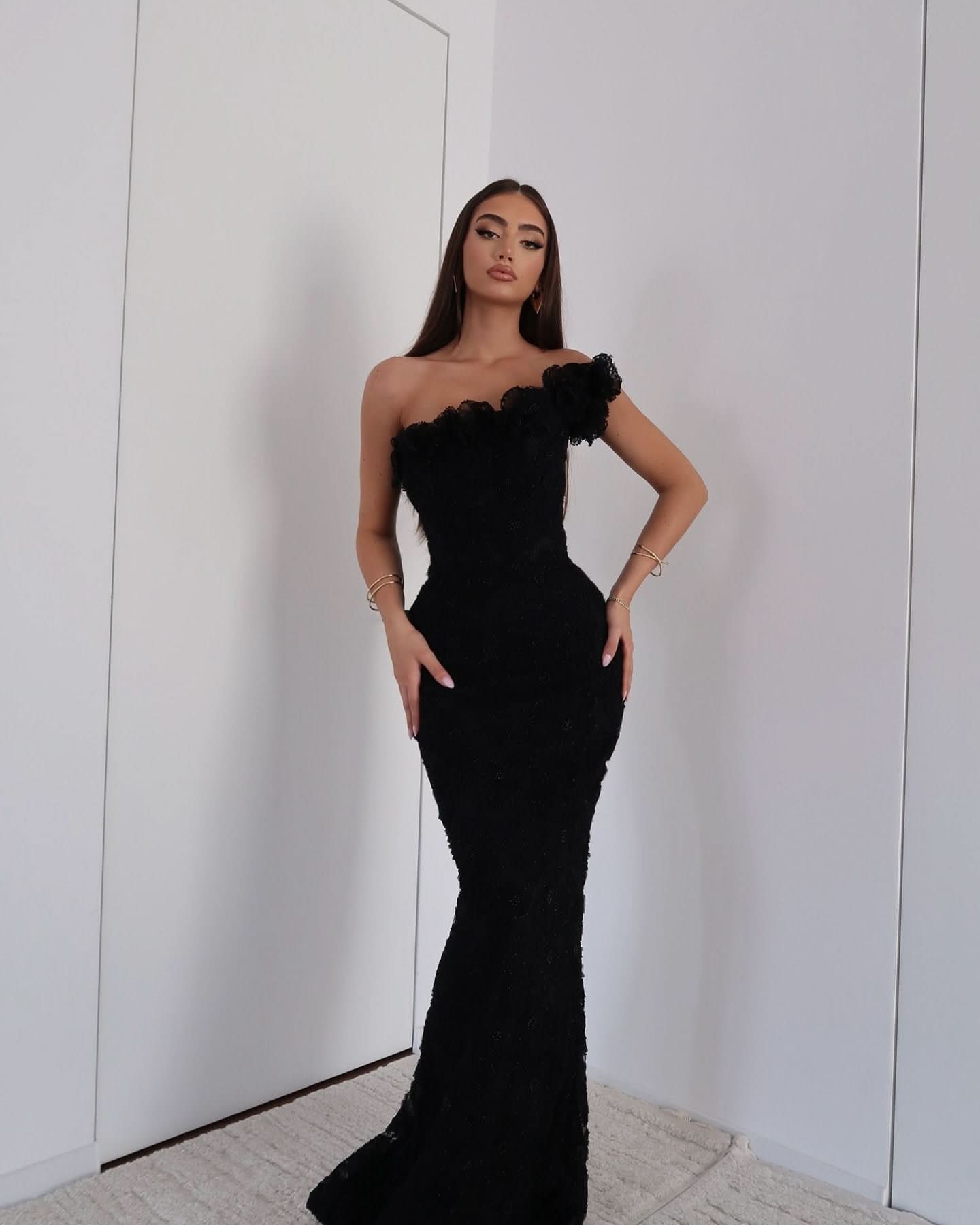 Black beaded asymmetrical off-shoulder maxi evening gown with sculpted silhouette