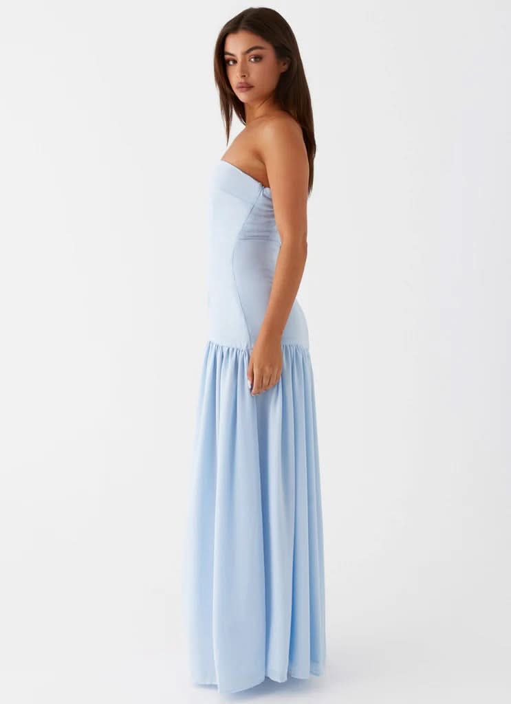 Side profile of light blue strapless maxi dress showing high leg slit