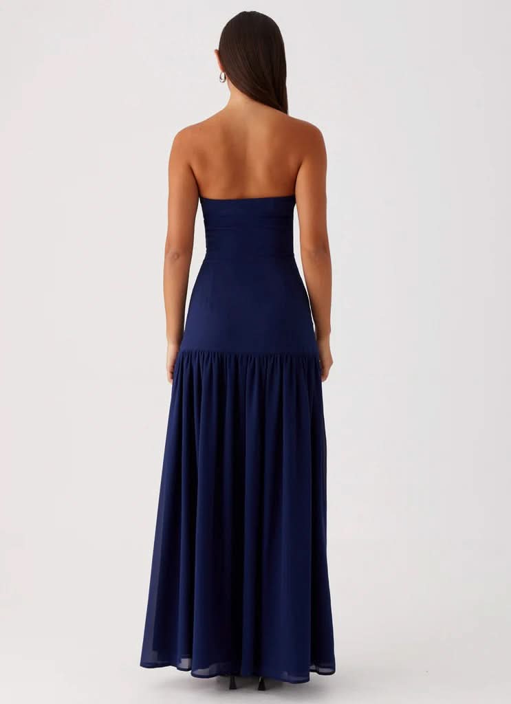 Navy strapless maxi dress with gathered waist and floor-length skirt, back view