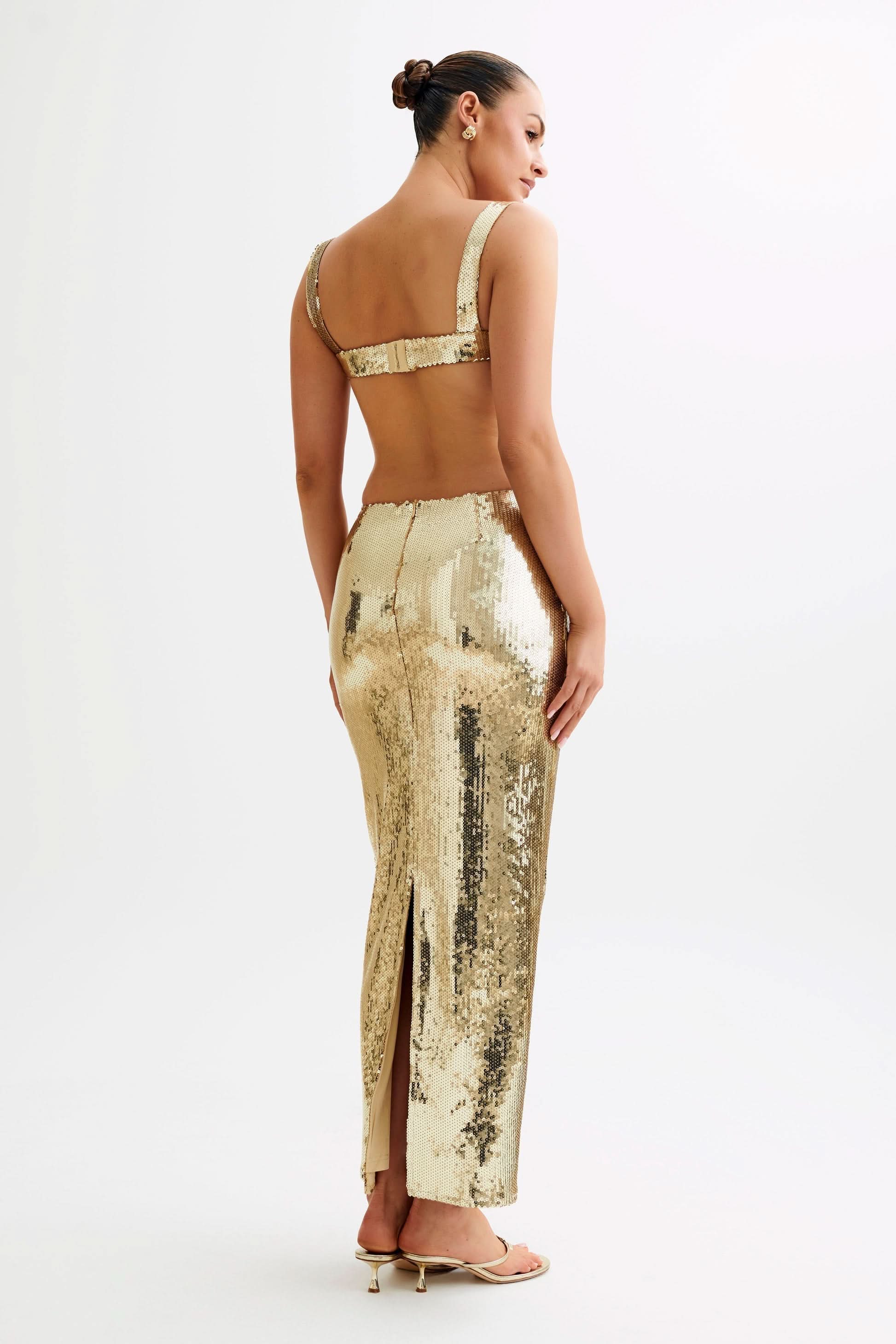 Back view of gold sequin maxi dress with open back cutout