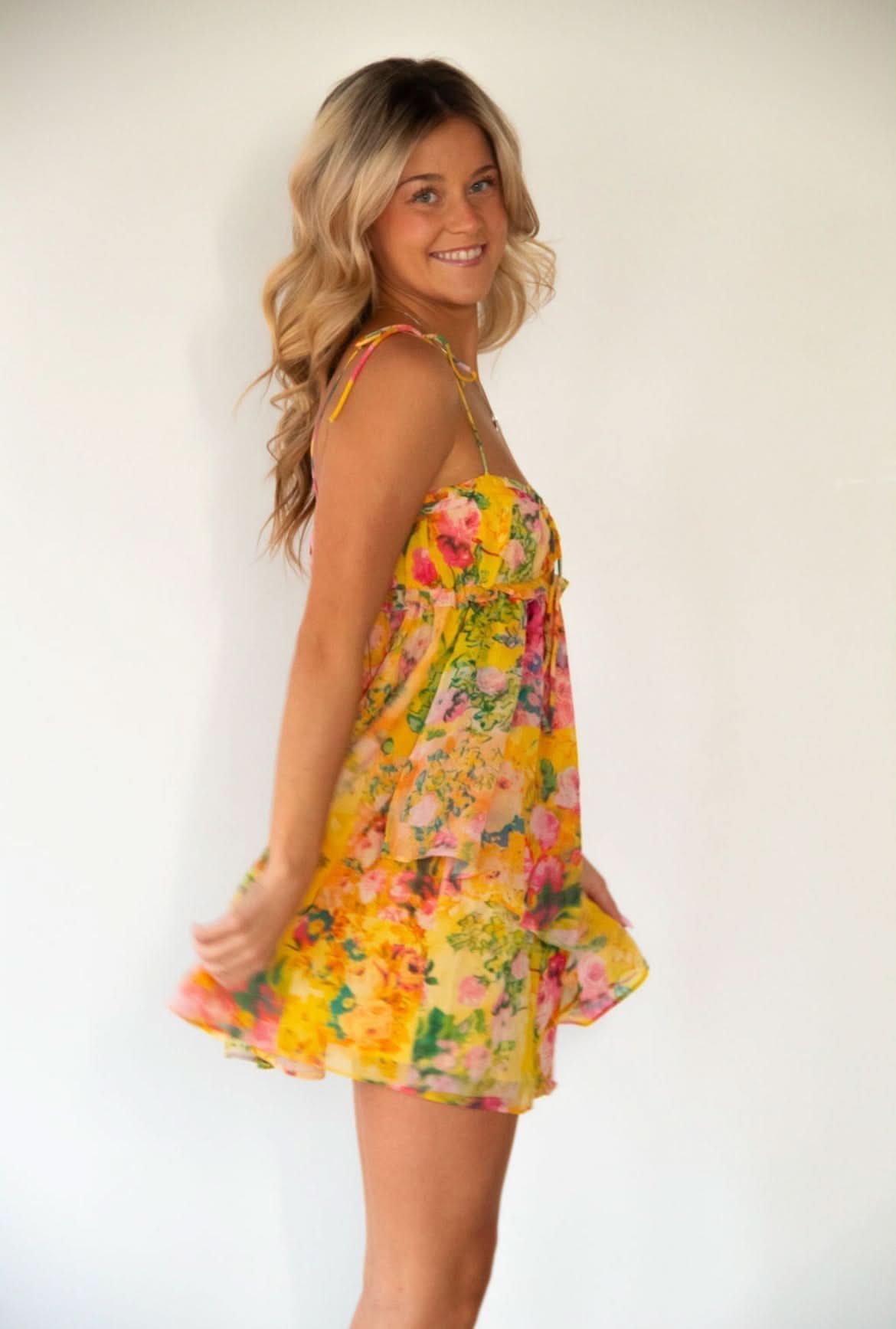 Side profile of floral mini dress with tie-dye effect and flowing skirt