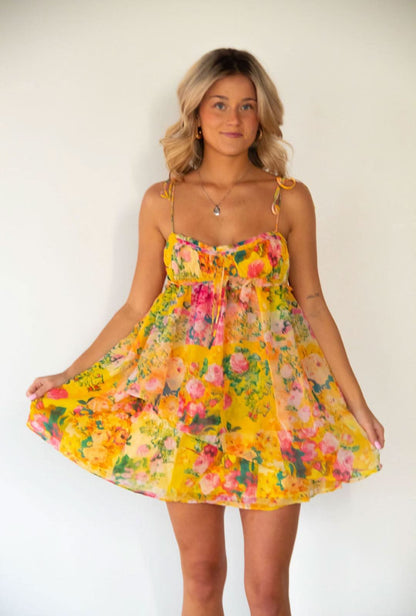 Front view of yellow floral mini dress with sweetheart neckline and gathered bodice