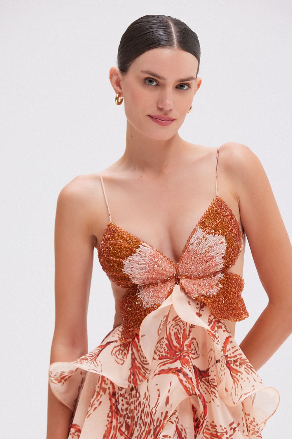 Beaded butterfly bodice detail on peach formal maxi dress with spaghetti straps