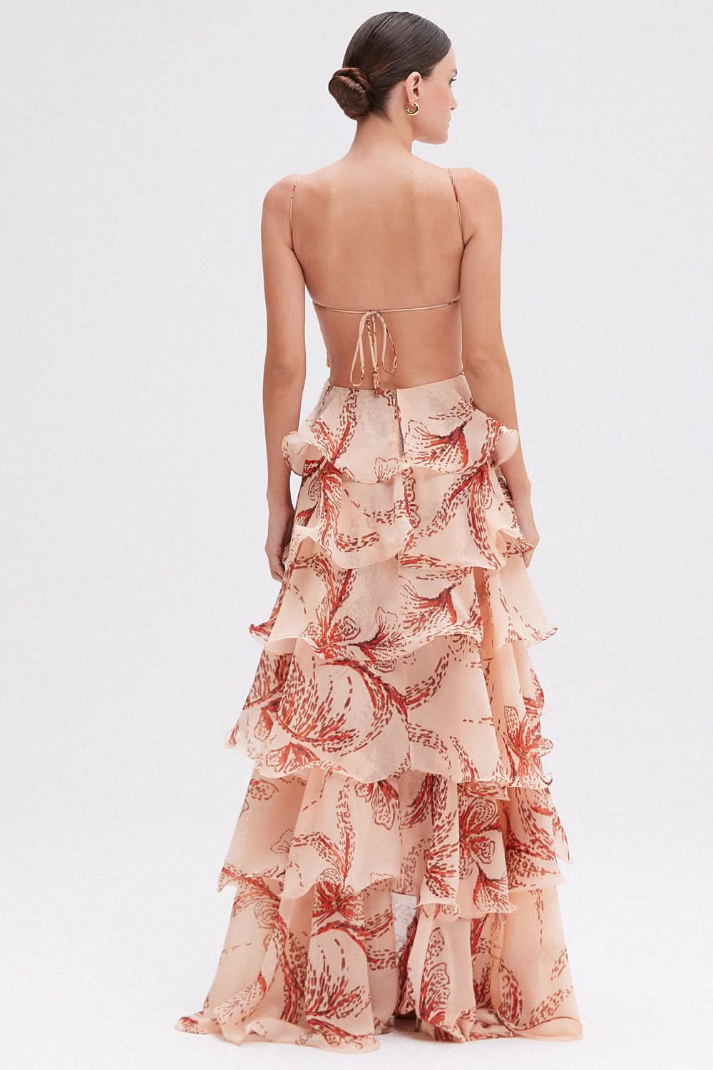 Open tie-back detail of peach botanical floral maxi dress with cascading ruffled layers