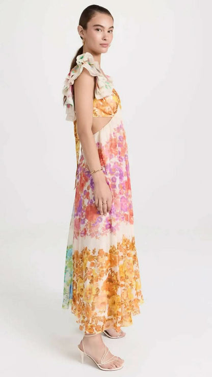 Side profile of women's floral midi dress showing back tie cutout detail and flowing hem