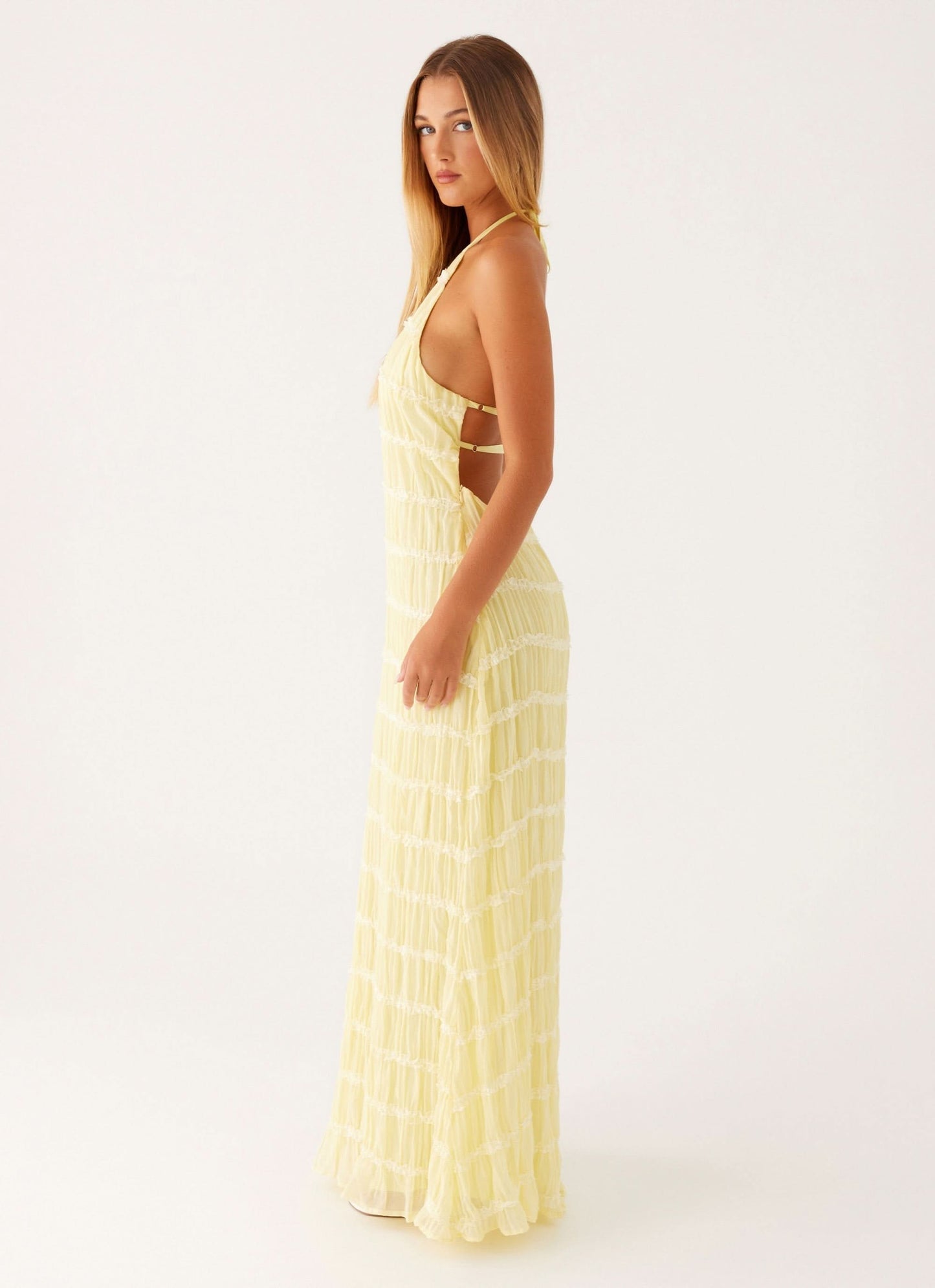 Pale yellow pleated halter maxi dress side view with open back