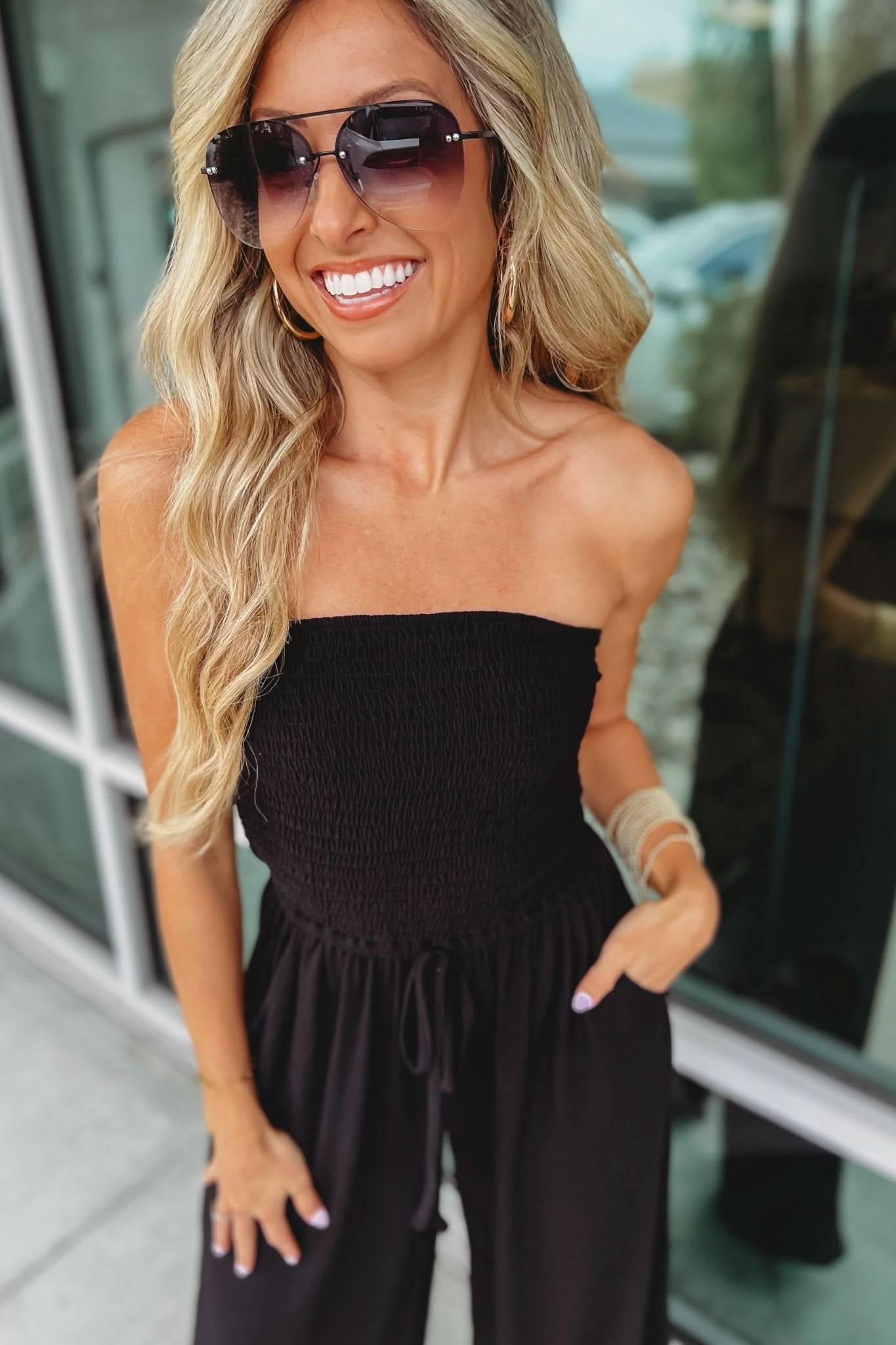 Black strapless jumpsuit close-up showing smocked chest detail