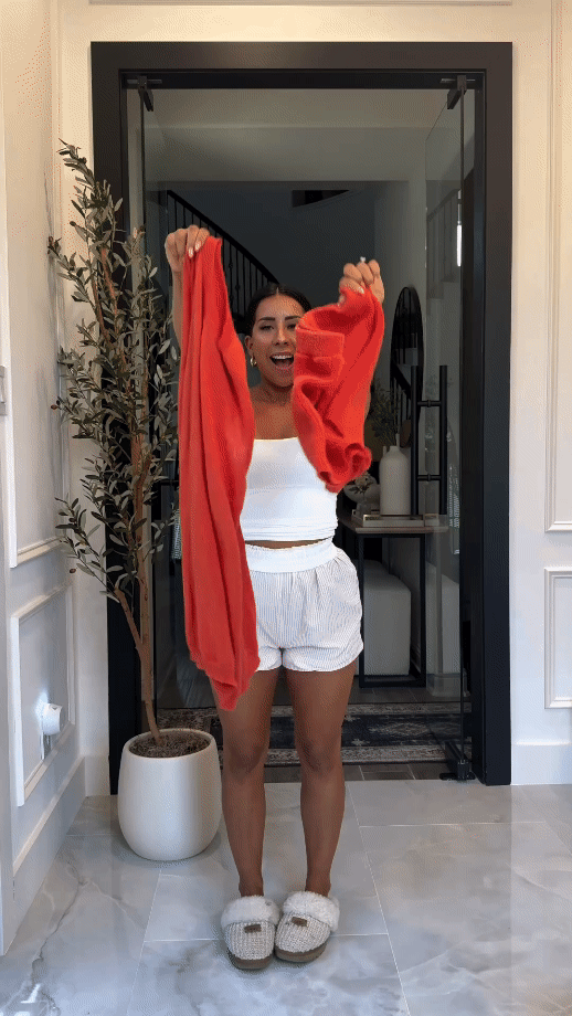 White ribbed shorts and red cardigan two-piece summer set indoors