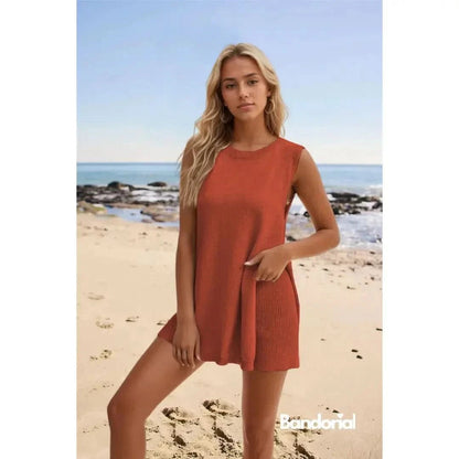 Rust-orange sleeveless mini dress with ribbed texture detail on beach