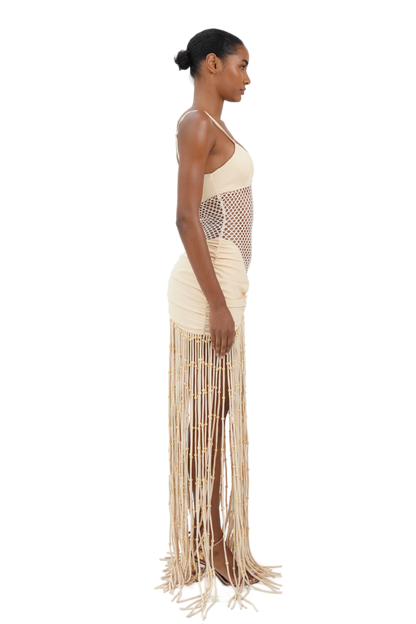 Cream maxi dress side view showing ruched fit and floor-length fringe detail