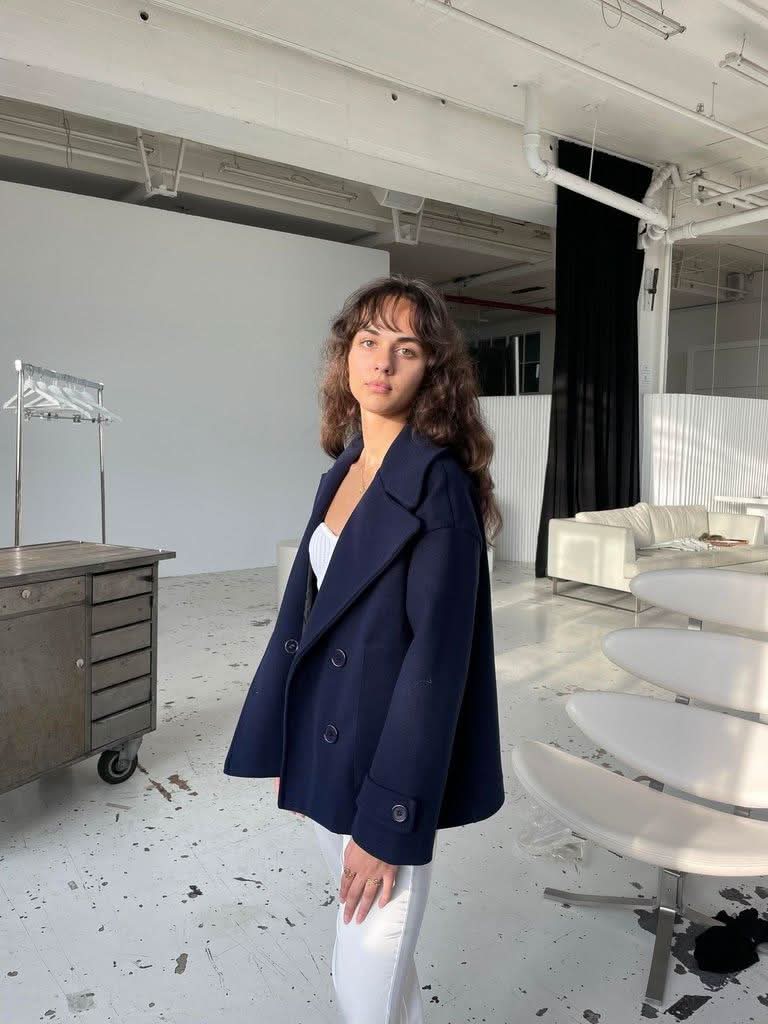 Side view of navy oversized coat with relaxed fit and rolled cuffs