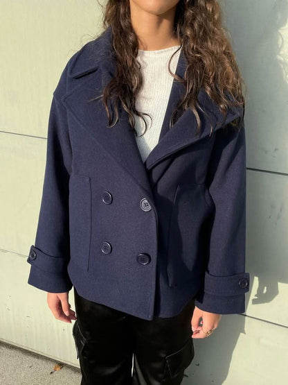 Close-up front detail of navy coat showing double-breasted buttons and lapel