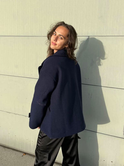 Back view of navy coat showing structured shoulders and length