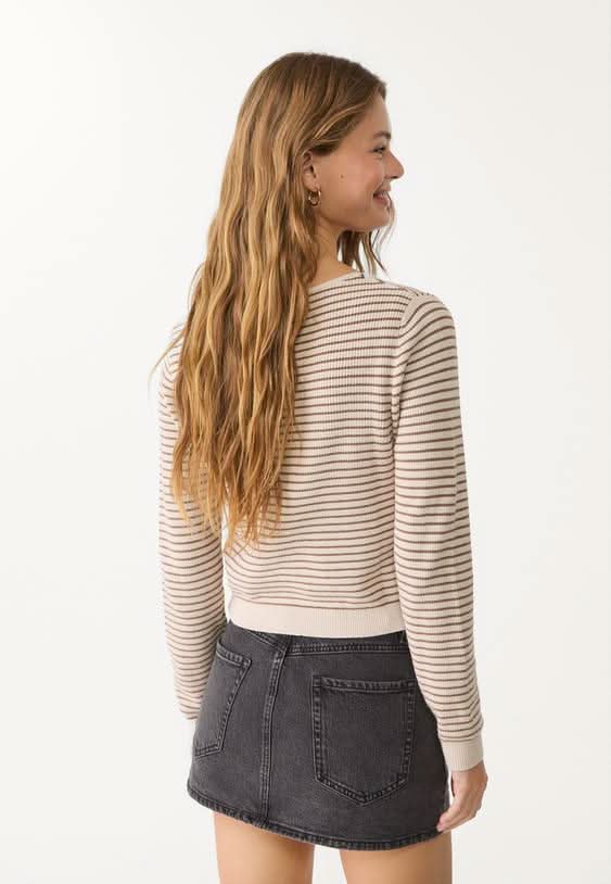 Charcoal gray denim skort styled with striped cream and tan sweater
