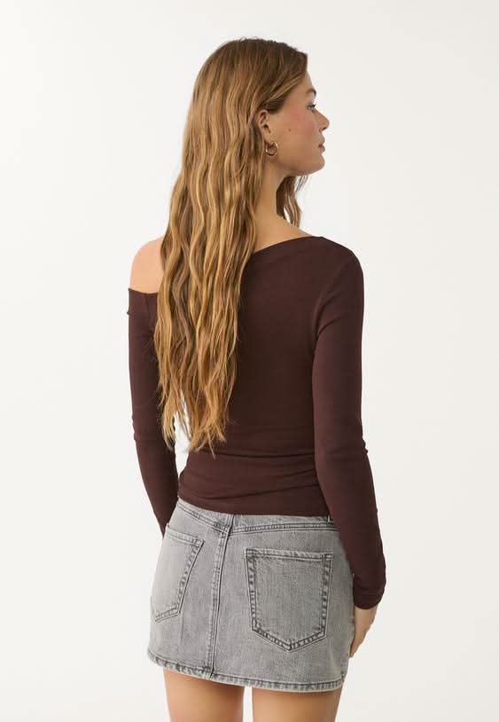 Light gray denim skort styled with burgundy long-sleeve top, side view