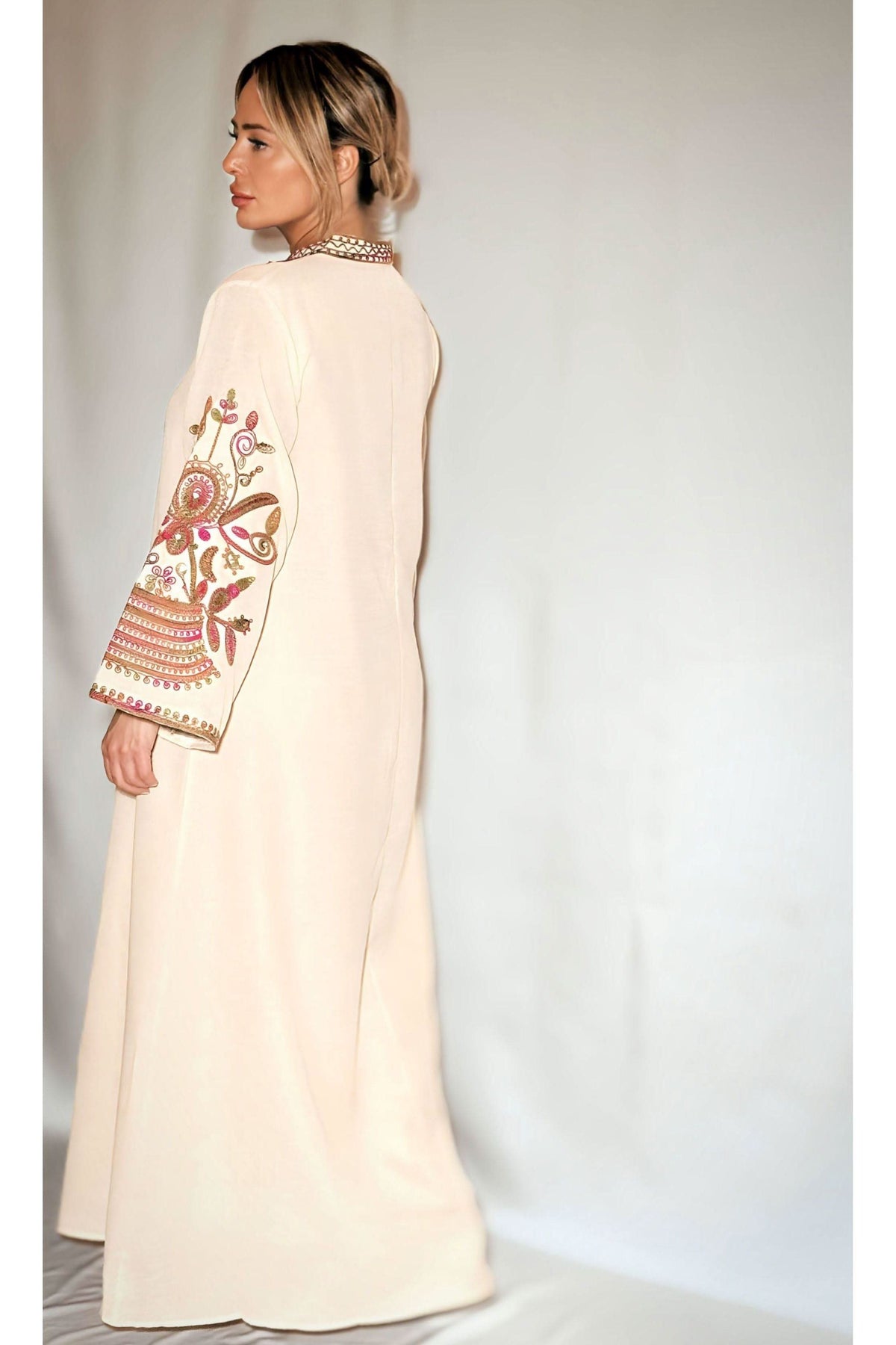 Back view of cream kaftan showing burgundy floral sleeve embroidery