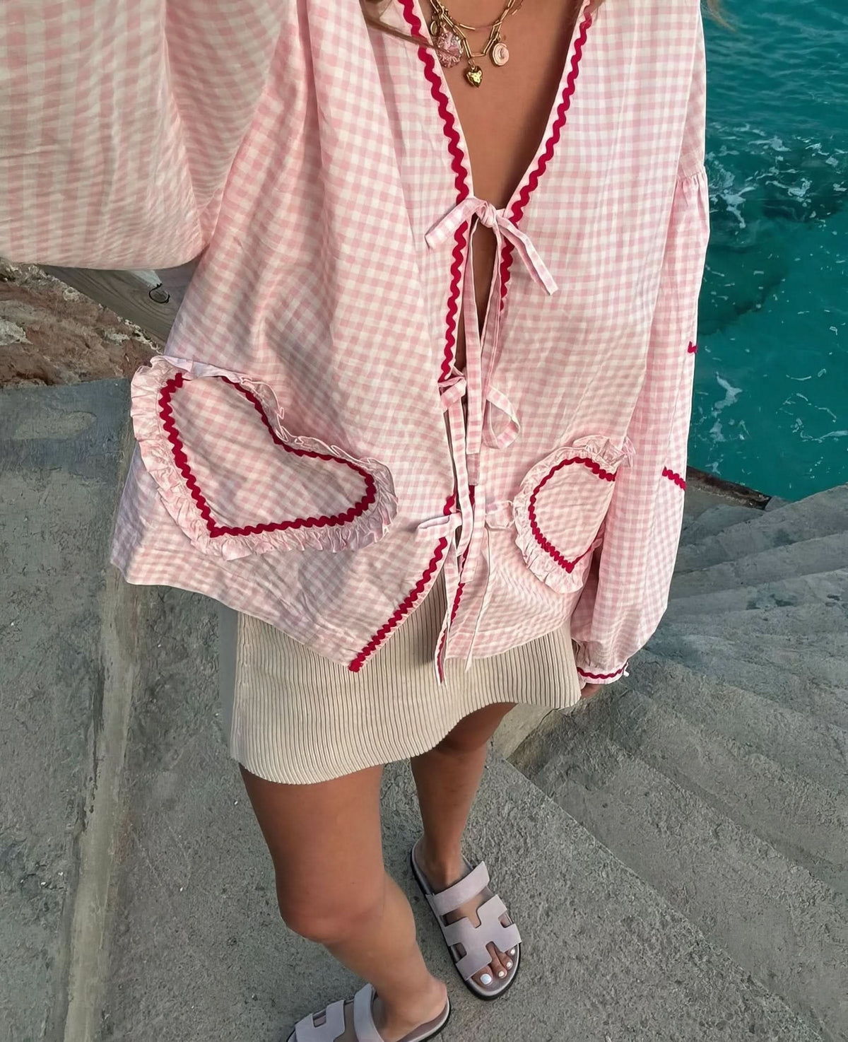 Front view of pink checkered heart top with burgundy wavy edges and pockets