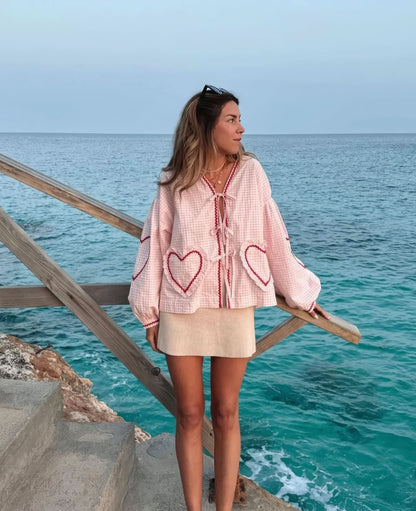Pink gingham heart top styled with cream ribbed skirt at coastal setting
