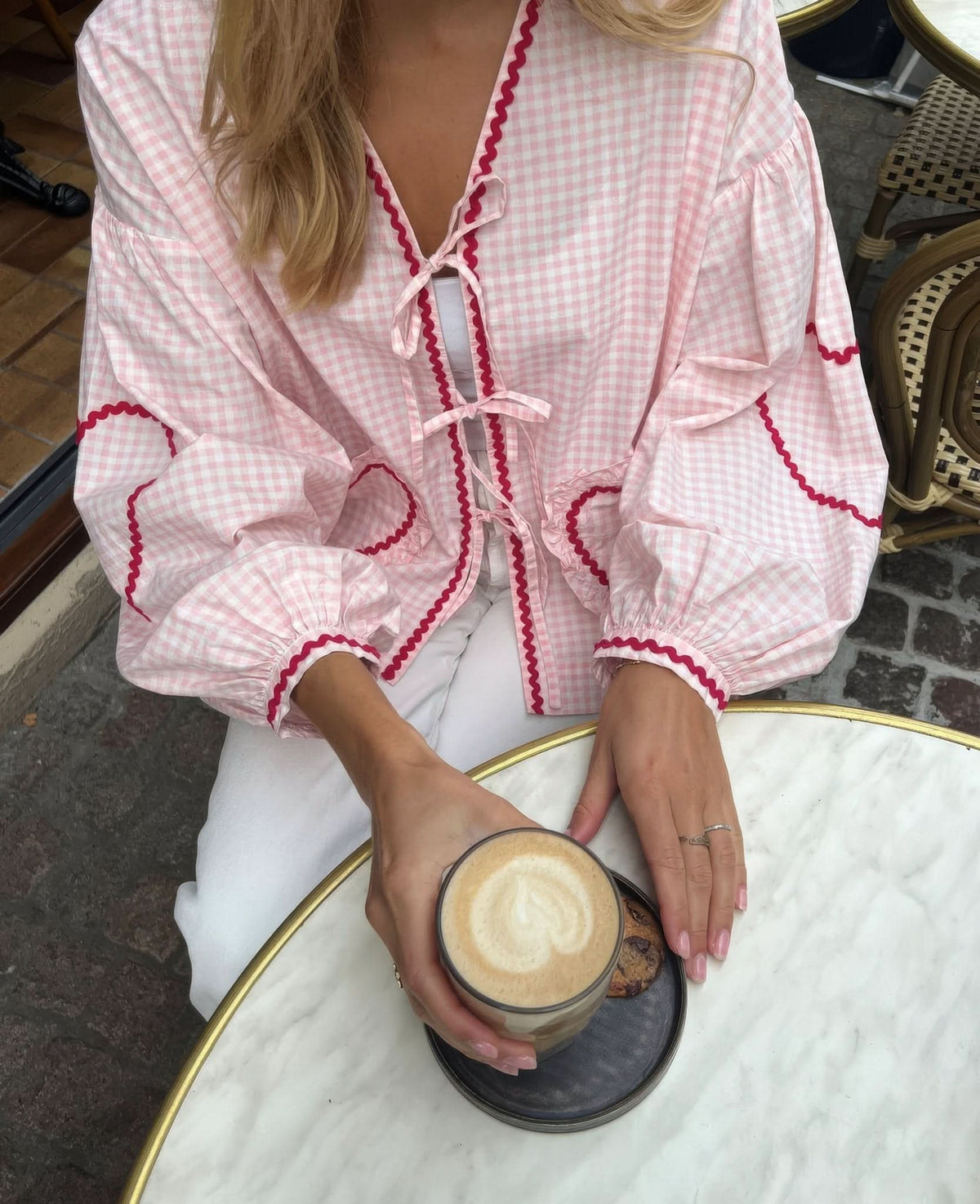 Pink gingham heart top with burgundy trim worn with white pants indoors