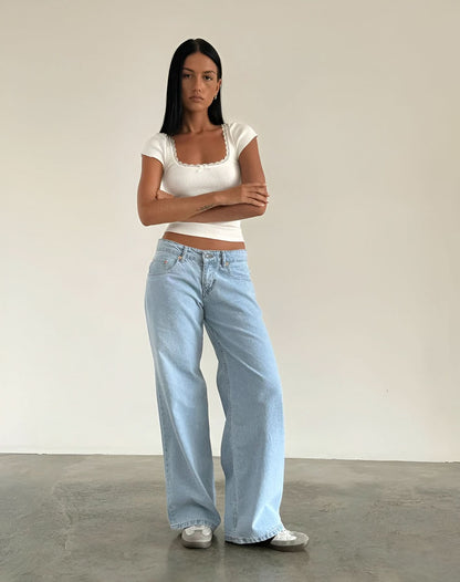 Light wash low-rise jeans with white lace-trim cap sleeve crop top