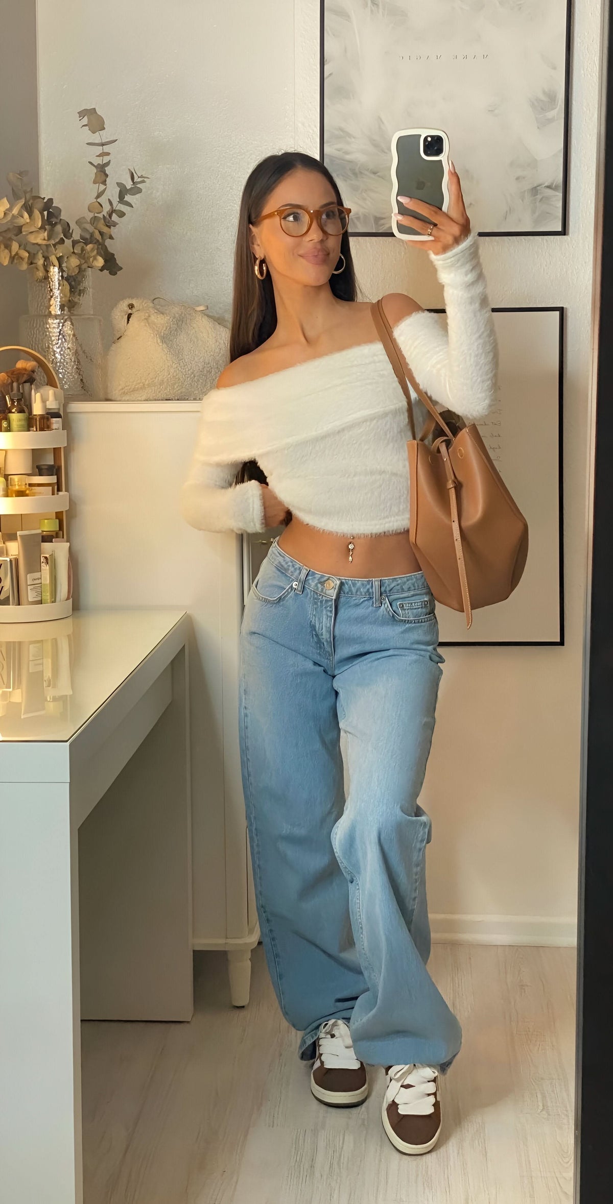 Light blue low-rise jeans with white off-shoulder top and brown shoulder bag
