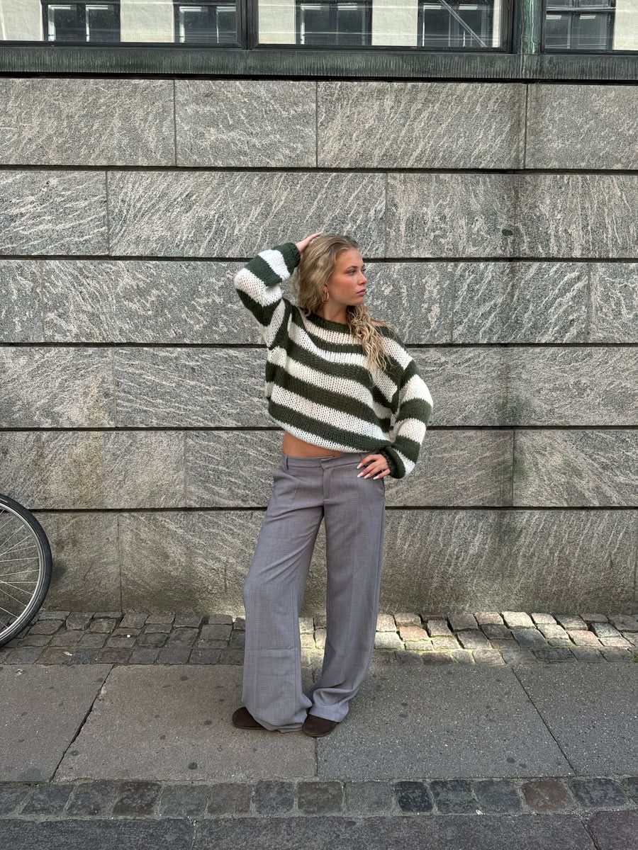 Green and white striped knit sweater with gray wide-leg trousers