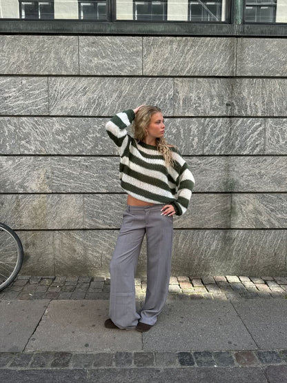 Green and white striped knit sweater with gray wide-leg trousers