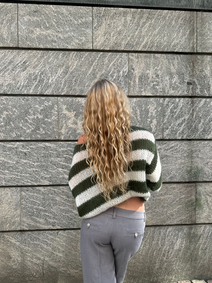 Back view of green and white striped knit sweater