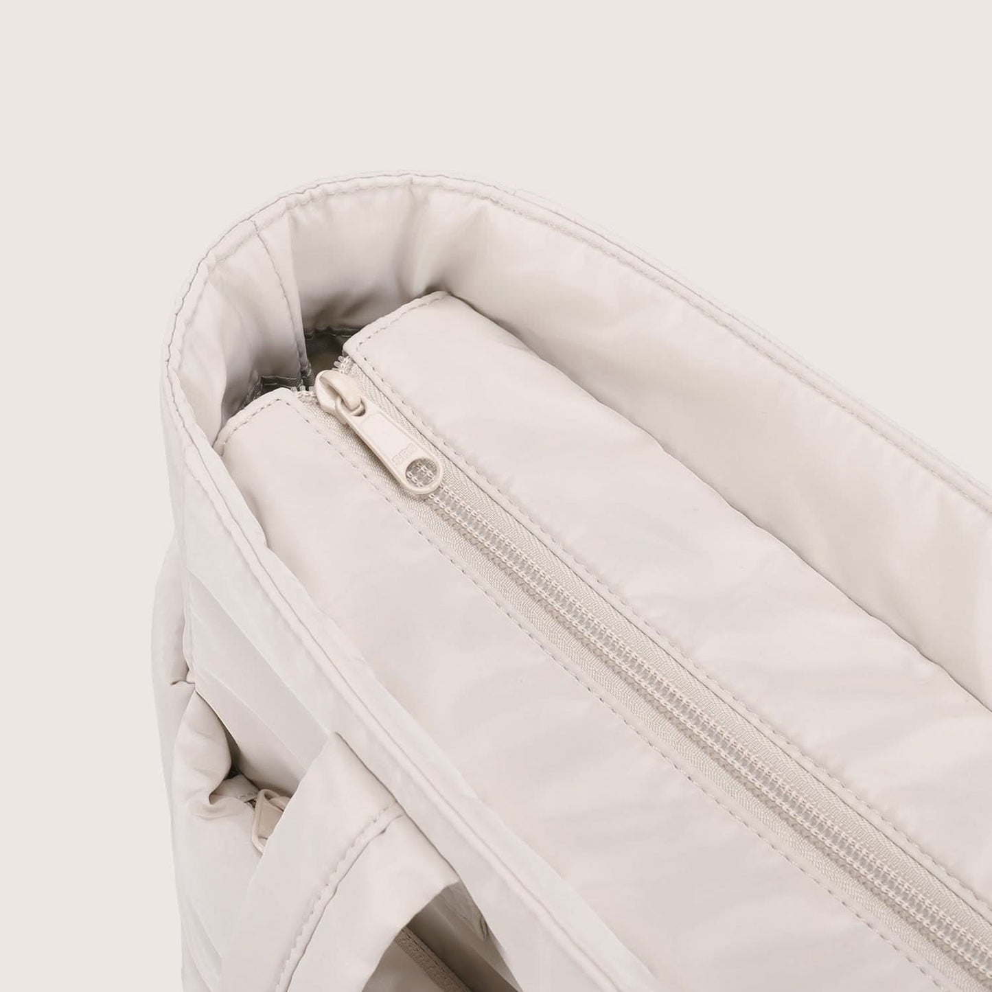 Close-up of cream tote interior zipper pocket with soft lining detail
