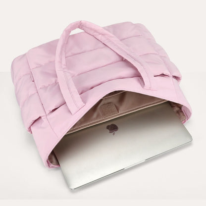Pink quilted city tote with laptop compartment holding silver laptop