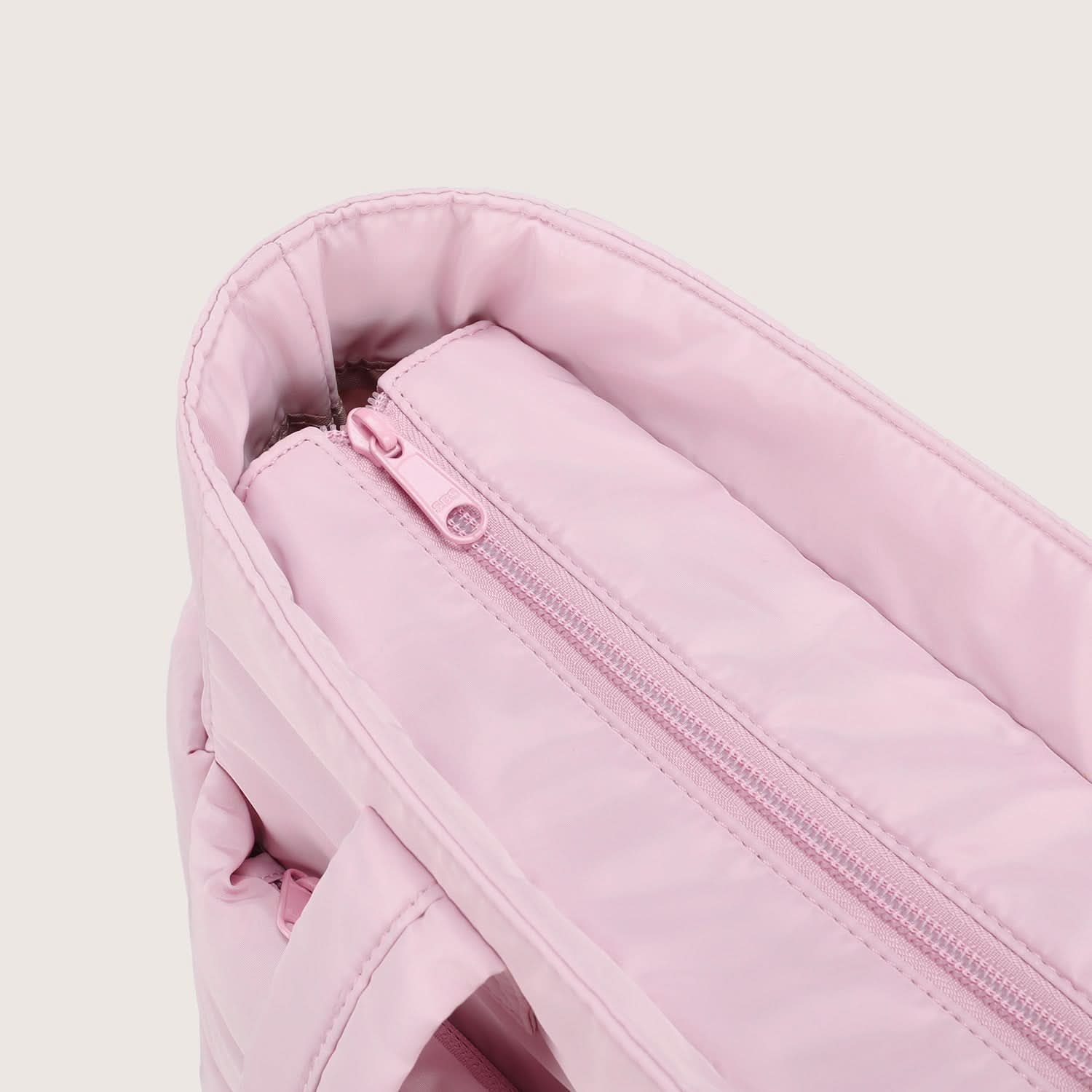 Close-up of pink padded tote interior zip pocket with pull tab