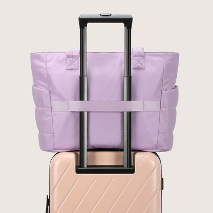 Lavender quilted tote on luggage handle showing travel-ready attachment strap