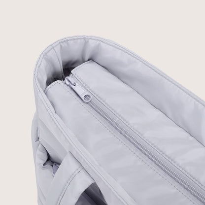 Close-up of light gray tote interior zip pocket with metal slider