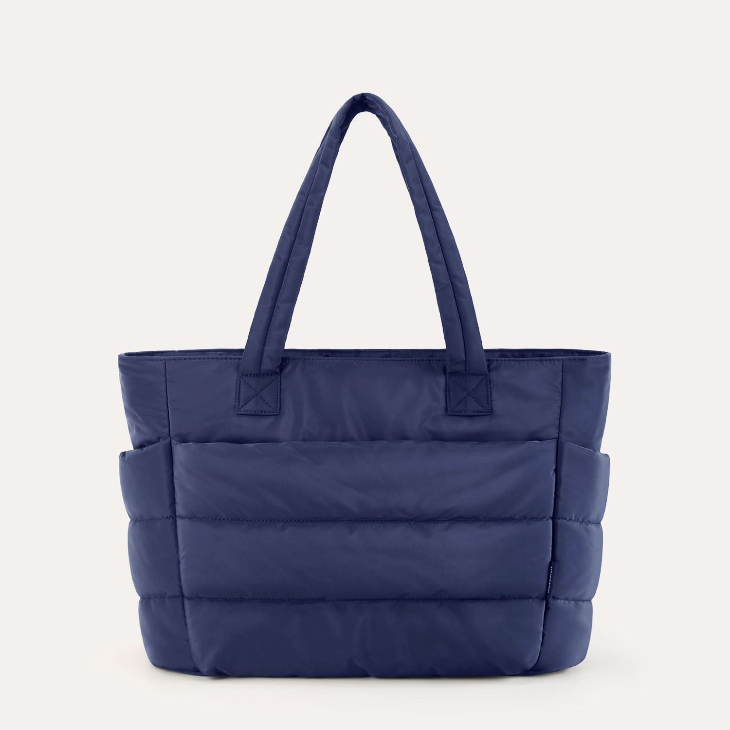 Navy blue padded tote with horizontal quilting and dual handles for daily use