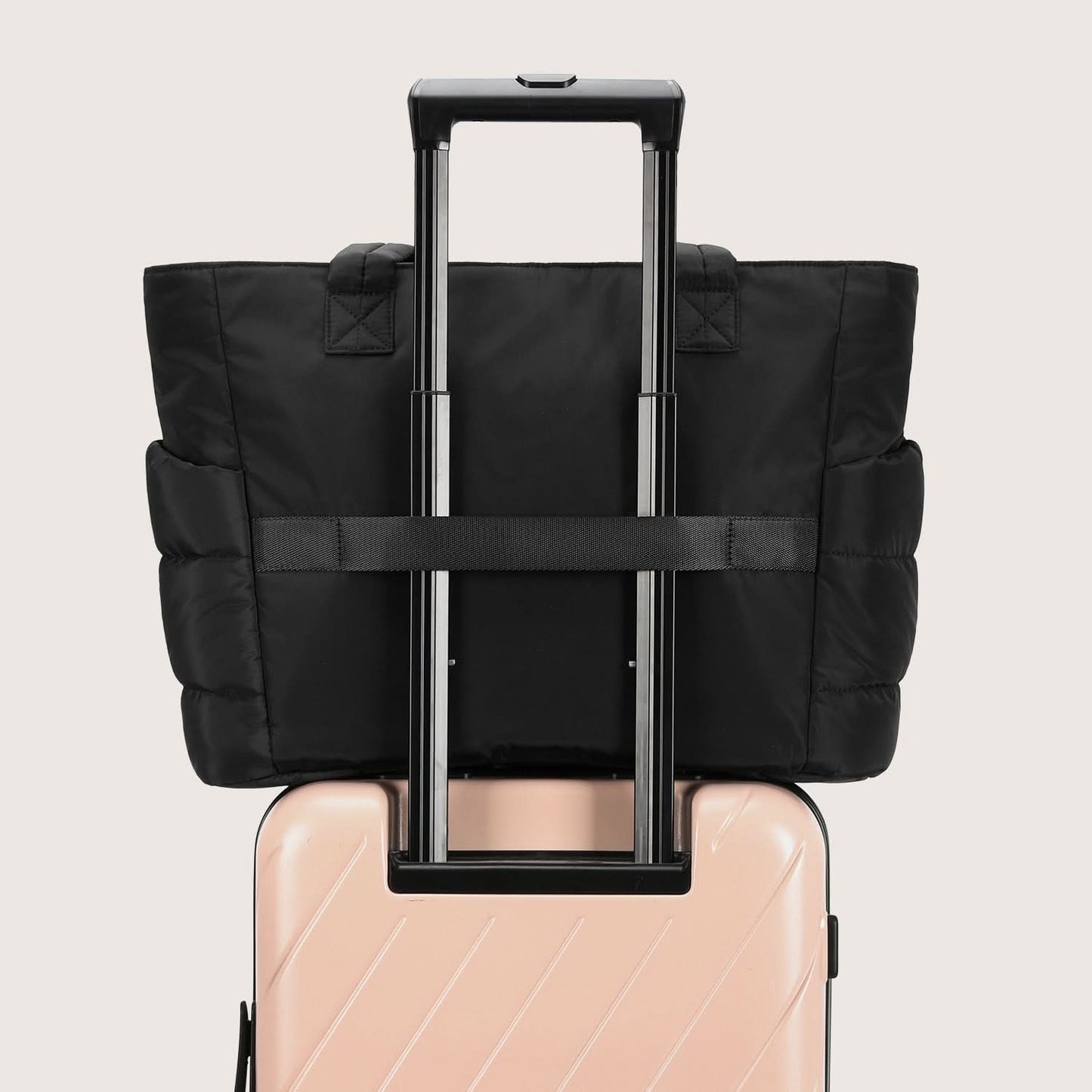 Black tote bag attached to luggage handle with expandable compartment design