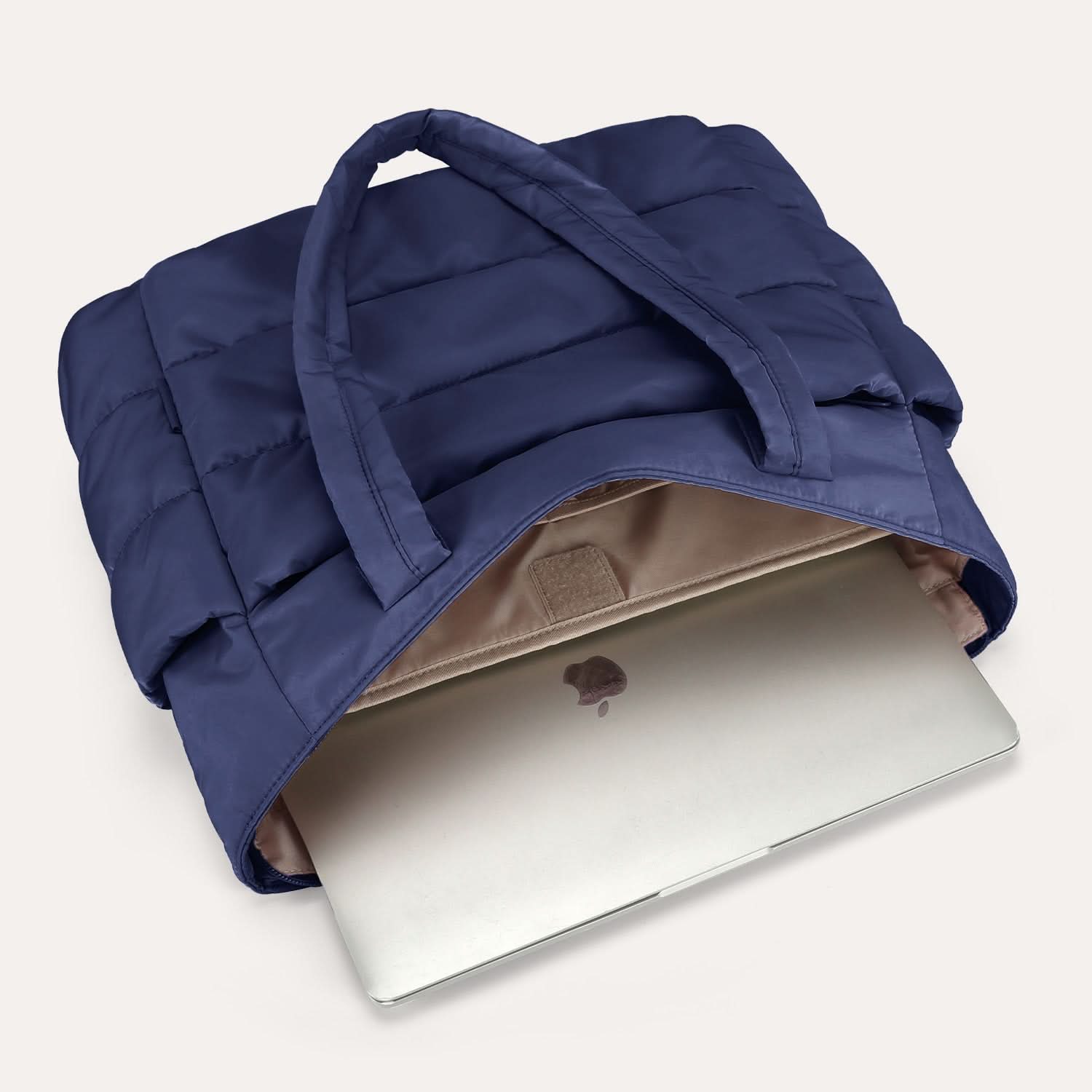 Navy quilted tote bag opened showing padded laptop compartment