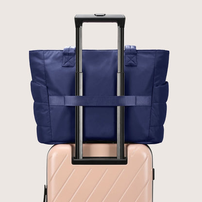 Navy tote with luggage pass-through strap on suitcase handle