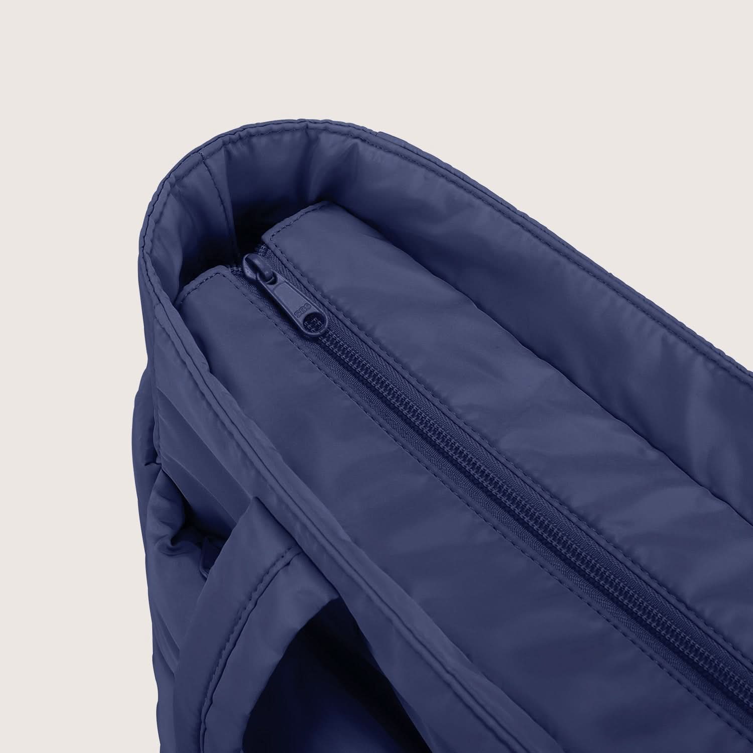 Close-up of navy tote interior zippered pocket with soft lining