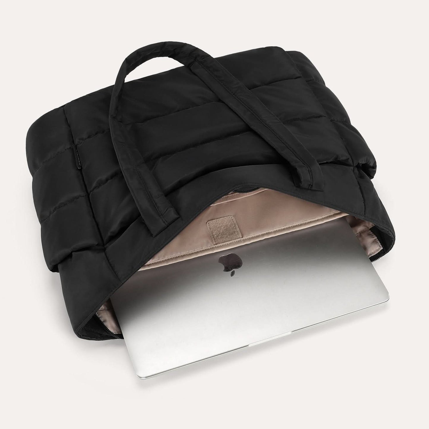 Black quilted tote with open laptop compartment showing protective padding