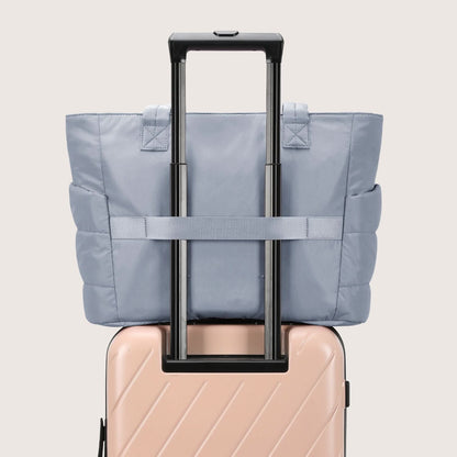 Light blue city tote bag attached to luggage handle with straps