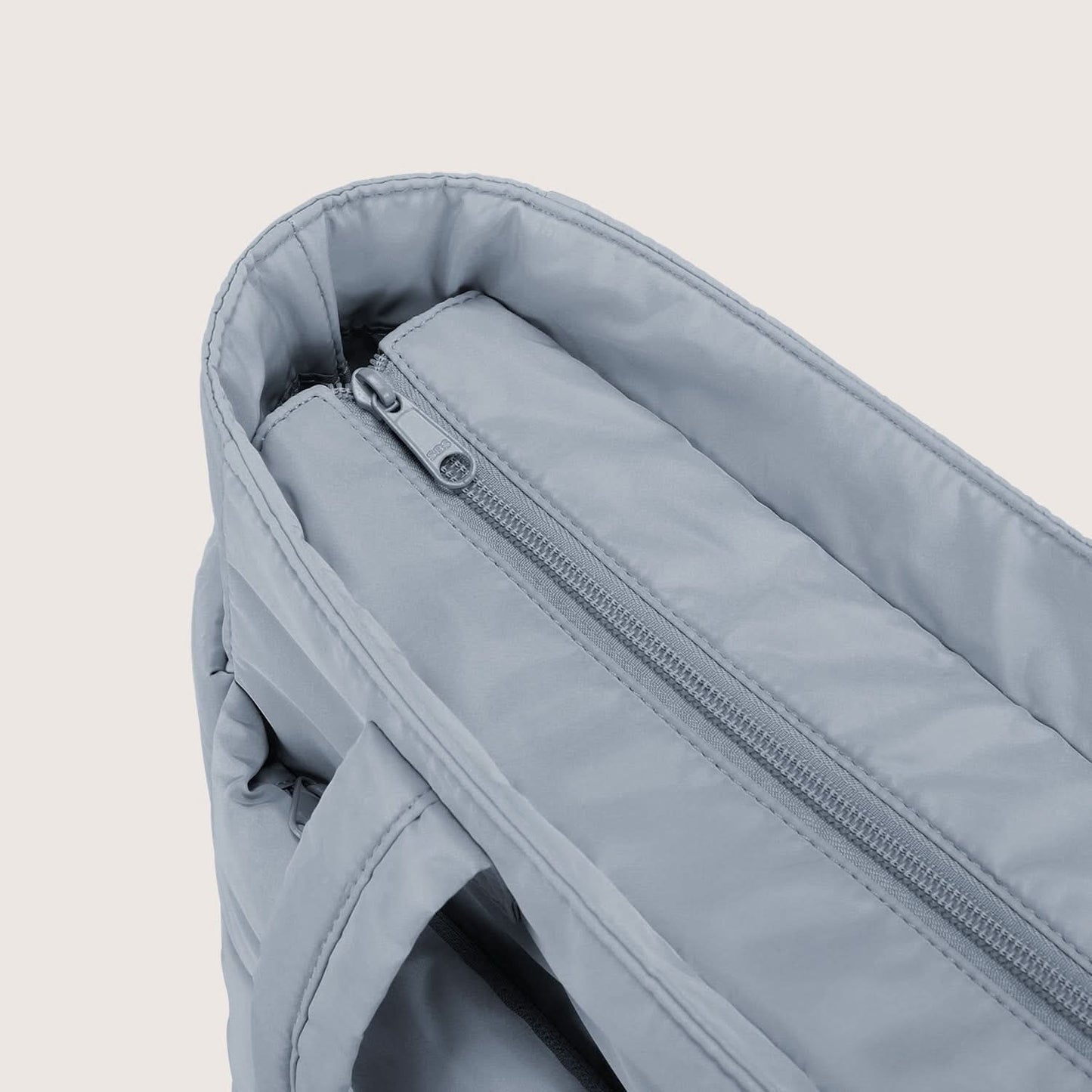 Close-up of light blue tote interior zippered pocket and soft lining