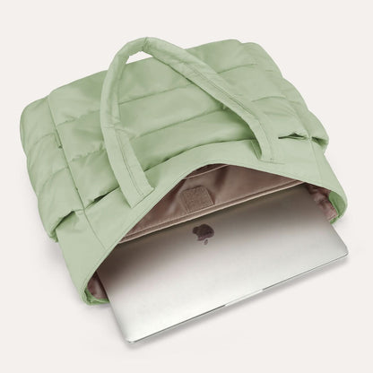 Light green padded city tote with laptop compartment on luggage handle
