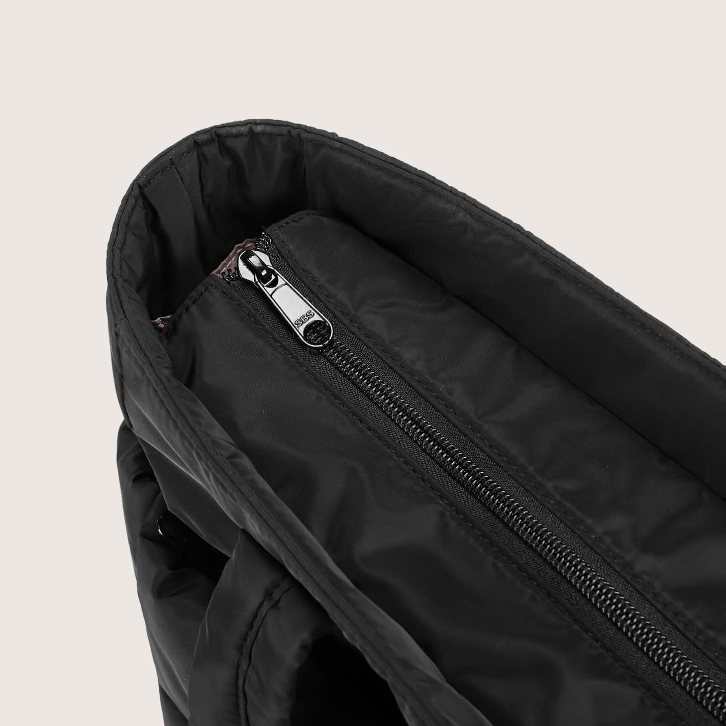 Close-up of black tote interior zip pocket with metal slider detail