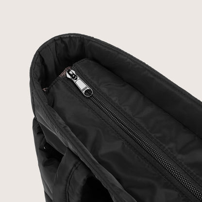 Close-up of black tote interior zip pocket with metal slider detail