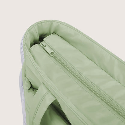 Sage green quilted tote bag interior with zippered pocket and handles