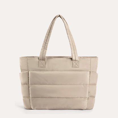 Cream quilted tote bag with horizontal stitch lines and handles