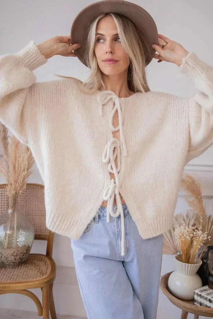 Front view of cream bow cardigan with adjustable lace-up neckline detail